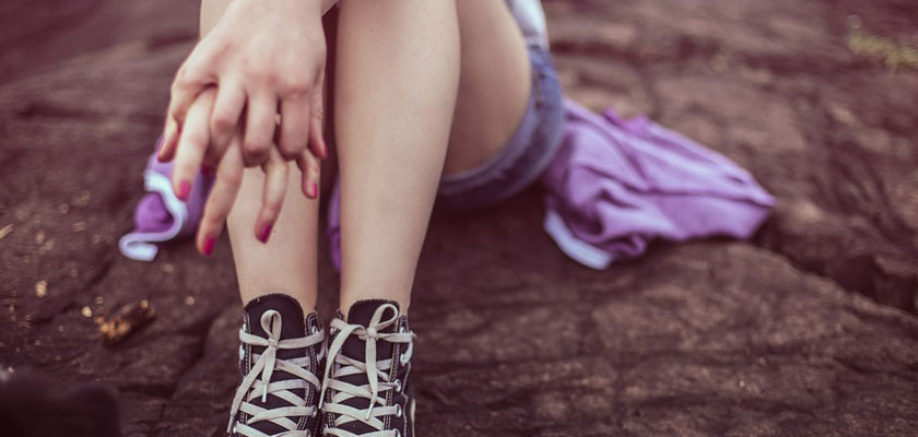 Las piernas de una chica joven sentada en el suelo con la depilación láser definitiva